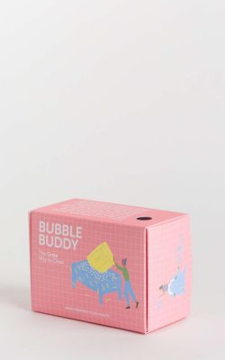 Prikazano je kartonsko pakiranje držača za sapune bubble buddy sa simpatičnim ilustracijama na rozoj podlozi.
