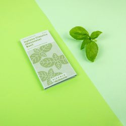 Zelena kutija sjemenki talijanskog bosiljka genovese na zelenoj podlozi, uz listić bosiljka