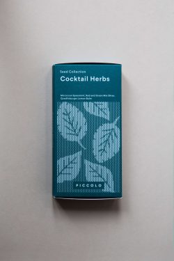 Plava kutija seta sjemenki sa začinima za koktele na sivoj podlozi