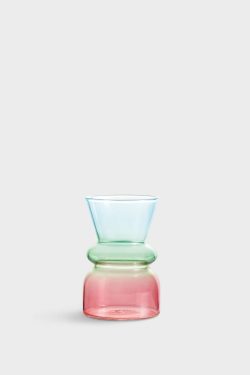 Na slici je prikazana staklena vaza u bojama koje se prelijevaju od ružičaste na dnu preko zelene u sredini do plave na vrhu. Vaza je trbušasta na dnu, ima zadebljanje u sredini, a na vrhu se otvara konusno.