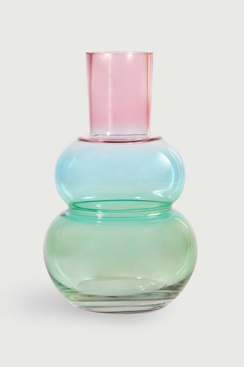 Na slici je prikazana staklena vaza u bojama koje se prelijevaju od zelene na dnu preko plave u sredini do ružičaste na vrhu. Vaza je trbušasta na dnu, ima zadebljanje u sredini, a vrh je stožast.