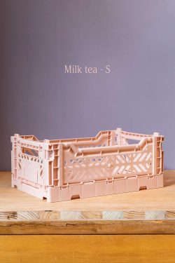 Na slici se vidi plastična kašeta u blijedorozoj boji. Kašeta stoji na drvenom stolu, ispred sive pozadine. Iznad kašete na pozadini je napisana boja kašete - Milk tea.