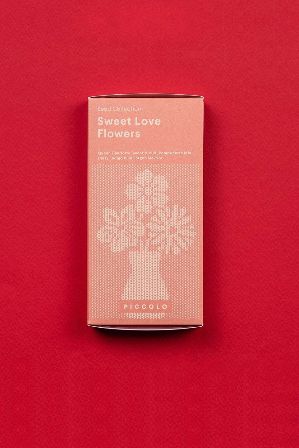 Crvena kutija seta sjemenki za sijanje cvijeća pod nazivom "Sweet love flowers" na crvenoj podlozi