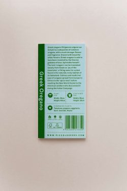 Zelena kutija sjemenki origana na sivoj podlozi. Vidi se stražnja strana kutije s tekstom.