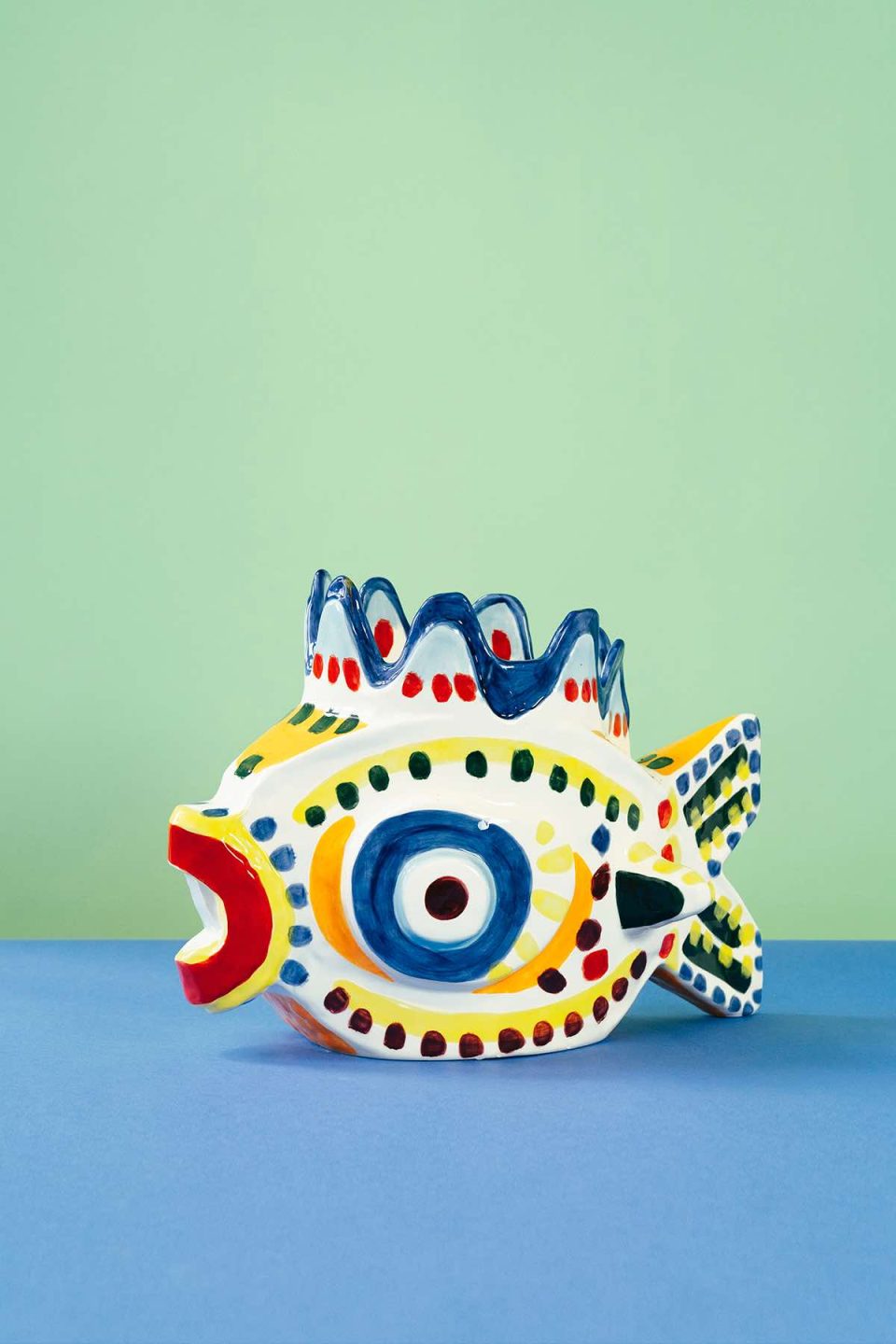 Keramička vaza u obliku ribe na zeleno plavoj podlozi